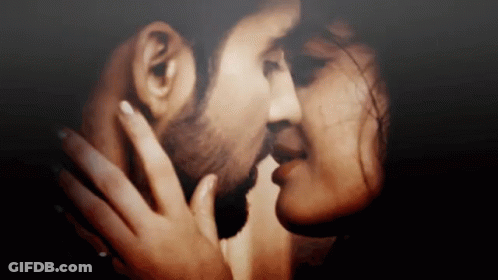 A Close Up Of A Man And Woman Kissing Each Other . GIF