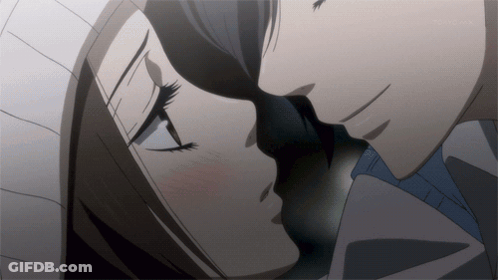 A Close Up Of A Man And Woman Kissing In A Dark Room GIF