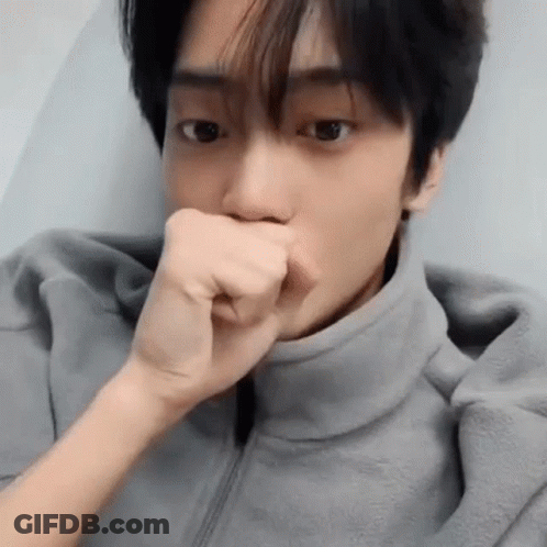 A Close Up Of A Man Covering His Mouth With His Fist . GIF
