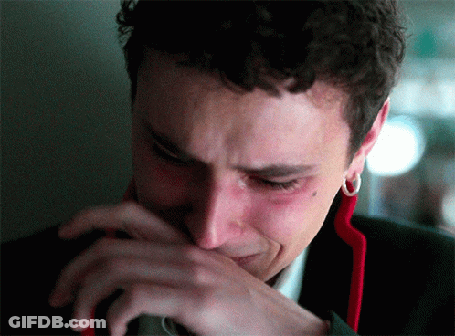 A Close Up Of A Man Crying With His Hand Over His Mouth GIF