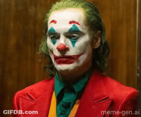 A Close Up Of A Man Dressed As The Joker In A Red Suit And Clown Makeup . GIF