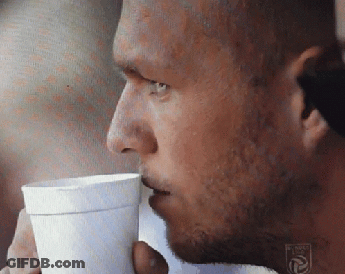 A Close Up Of A Man Drinking From A Cup That Says Bundesliga On It GIF