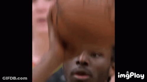 A Close Up Of A Man Holding A Basketball Over His Head GIF