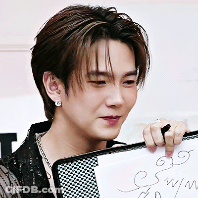 A Close Up Of A Man Holding A Piece Of Paper That Says ' Symph ' On It GIF