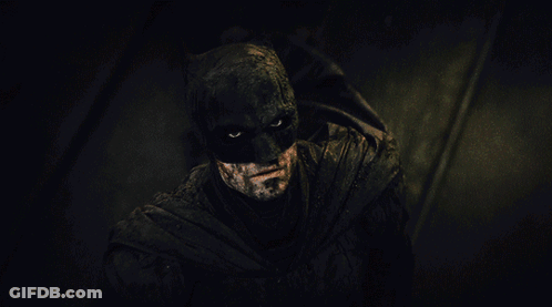 A Close Up Of A Man In A Batman Costume In The Dark GIF