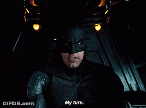 A Close Up Of A Man In A Batman Costume Saying My Turn GIF