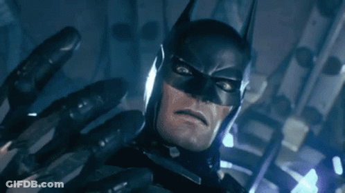 A Close Up Of A Man In A Batman Costume With A Glove On His Hand . GIF