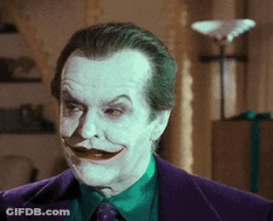 A Close Up Of A Man In A Purple Suit With A Green Shirt And Tie GIF