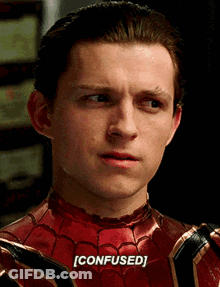 A Close Up Of A Man In A Spiderman Costume With The Word Confused Written On His Face . GIF