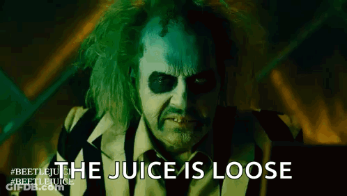 A Close Up Of A Man In A Striped Suit With The Words `` The Juice Is Loose '' Written On His Face . GIF