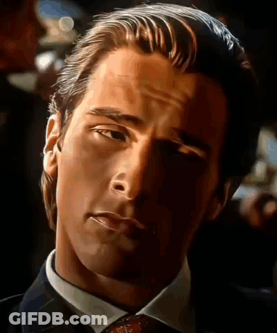 A Close Up Of A Man In A Suit And Tie Looking At The Camera GIF