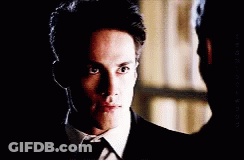 A Close Up Of A Man In A Suit And Tie Looking At The Camera GIF