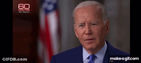 A Close Up Of A Man In A Suit And Tie With An American Flag In The Background . GIF