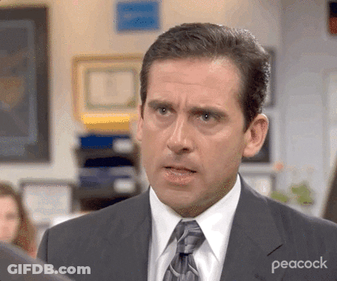 A Close Up Of A Man In A Suit And Tie With Peacock Written On His Chest GIF