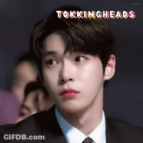 A Close Up Of A Man In A Suit And Tie With The Words Tokingheads Written Above Him . GIF