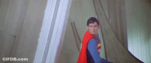 A Close Up Of A Man In A Superman Costume Flying Through The Air . GIF