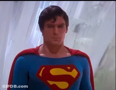 A Close Up Of A Man In A Superman Costume With A Cape . GIF