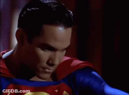 A Close Up Of A Man In A Superman Costume With A Red Cape . GIF