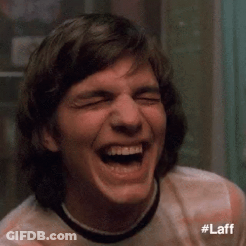 A Close Up Of A Man Laughing With His Eyes Closed And His Mouth Open . GIF