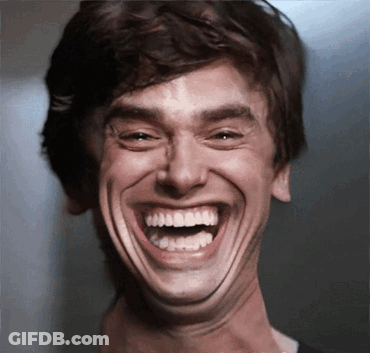 A Close Up Of A Man Laughing With His Mouth Open GIF