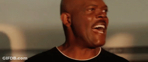 A Close Up Of A Man Laughing With His Mouth Open GIF