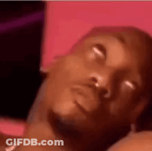 A Close Up Of A Man Laying Down With His Eyes Closed . GIF