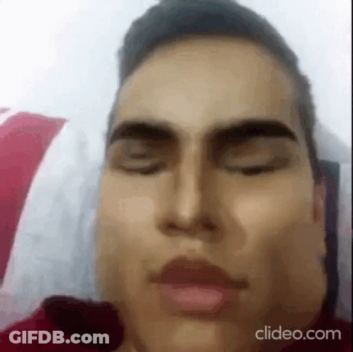 A Close Up Of A Man Laying In Bed With His Eyes Closed . GIF