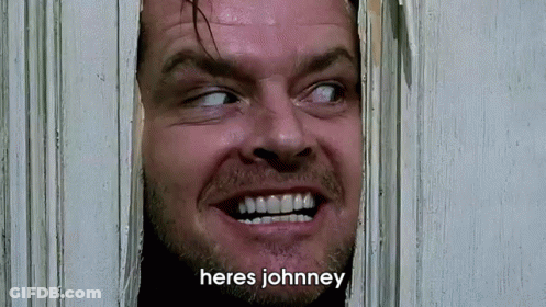 A Close Up Of A Man Looking Through A Door With The Words Heres Johnney Written Below Him GIF