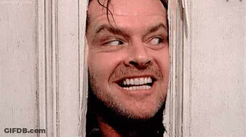 A Close Up Of A Man Looking Through A Door GIF