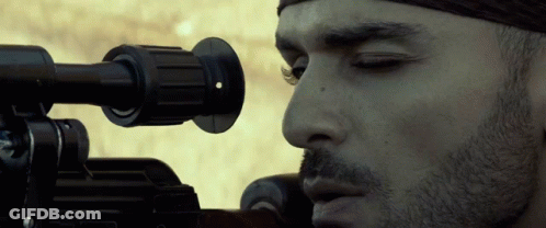 A Close Up Of A Man Looking Through A Sniper Rifle GIF