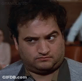 A Close Up Of A Man Making A Funny Face While Sitting At A Table . GIF