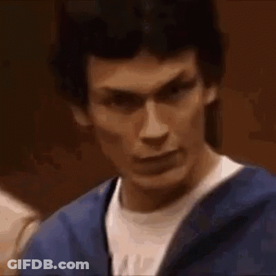 A Close Up Of A Man Making A Funny Face While Wearing A Blue Jacket And A White Shirt . GIF