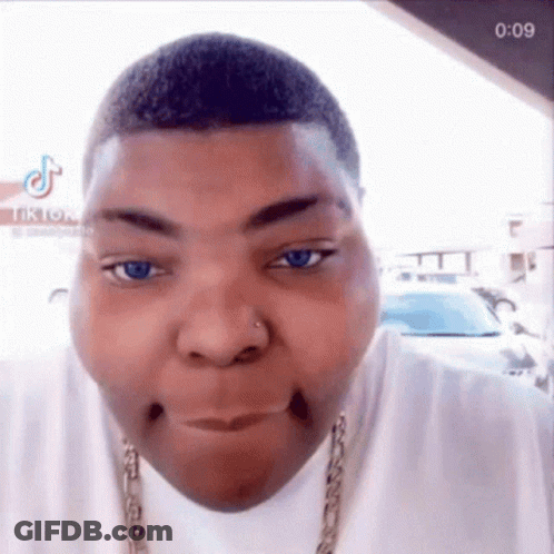 A Close Up Of A Man Making A Funny Face While Wearing A Chain Around His Neck . GIF