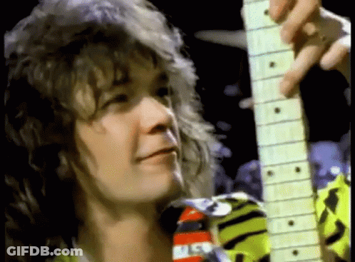 A Close Up Of A Man Playing A Guitar In A Dark Room . GIF