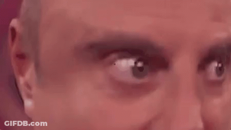 A Close Up Of A Man 'S Eyes Looking At The Camera With A Red Background . GIF