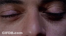 A Close Up Of A Man 'S Eyes With A Slight Smirk On His Face . GIF