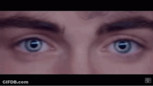 A Close Up Of A Man 'S Eyes With Blue Lenses GIF