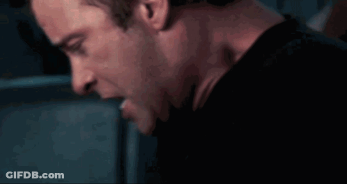 A Close Up Of A Man 'S Face And Neck In A Dark Room GIF