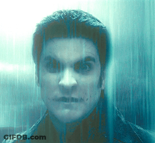A Close Up Of A Man 'S Face Behind A Glass Door GIF