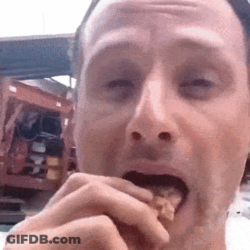 A Close Up Of A Man 'S Face Eating Something GIF
