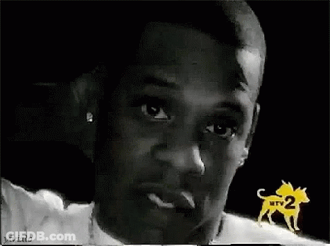 A Close Up Of A Man 'S Face In A Black And White Photo With A Dog In The Background . GIF