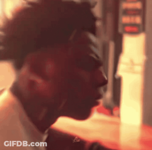 A Close Up Of A Man 'S Face In A Blurry Photo With A Red Background . GIF