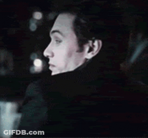 A Close Up Of A Man 'S Face In A Dark Room . GIF