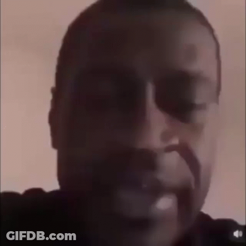 A Close Up Of A Man 'S Face In A Dark Room . GIF