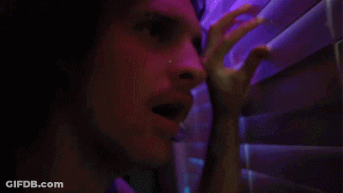 A Close Up Of A Man 'S Face In A Dark Room GIF