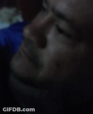 A Close Up Of A Man 'S Face In A Dark Room GIF