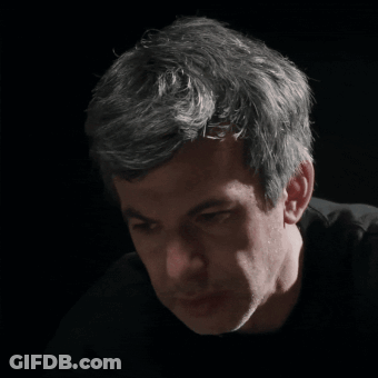 A Close Up Of A Man 'S Face In A Dark Room GIF