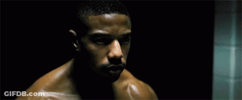 A Close Up Of A Man 'S Face In A Dark Room . GIF