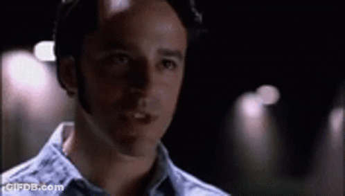 A Close Up Of A Man 'S Face In A Dark Room With A Blurred Background . GIF