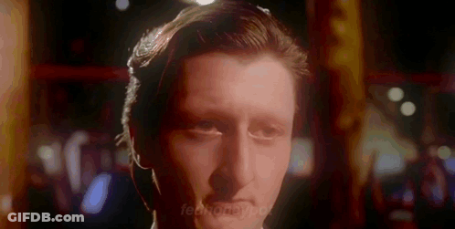 A Close Up Of A Man 'S Face In A Dark Room With A Blurred Background GIF